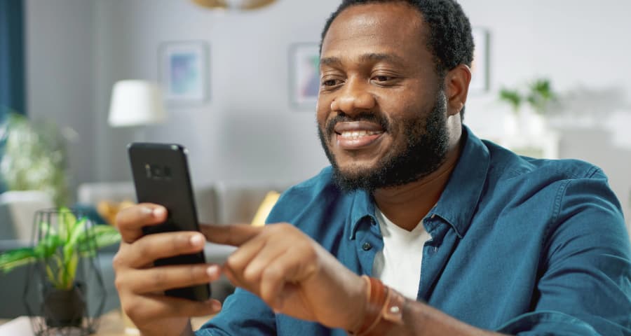 Man sitting down navigating an app on his smartphone